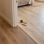 Стык нового напольного покрытия в комнате с готовым полом коридора у дверного проёма